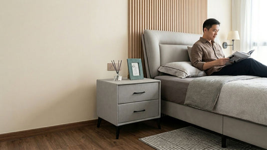 Modern bedroom featuring a grey upholstered bedside table styled beside a fabric bed, showcasing ideal bedside table height, size, and bedroom styling considerations.