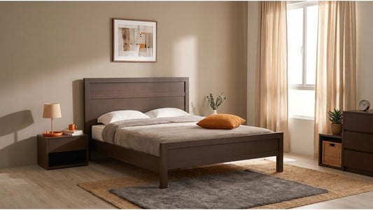 Dark oak bed frame in a warm Singapore bedroom with matching bedside table, dresser, rugs, and natural window light