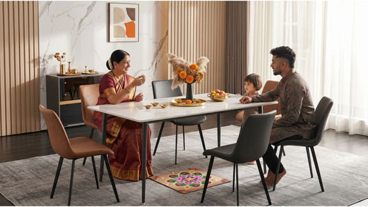Family celebrating Deepavali around a white dining table in a modern Singapore home with rangoli, festive decor, and dining chairs