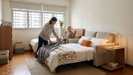 Caregiver preparing a sofa bed beside an elderly parent’s bed in a bright Singapore bedroom