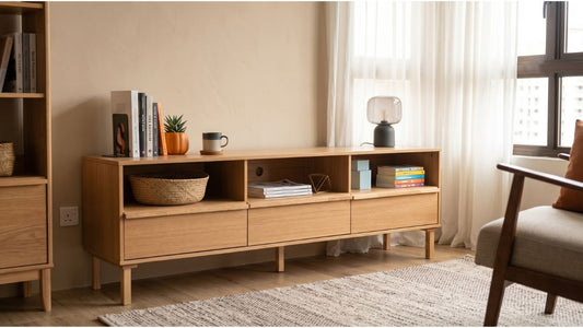 Light wood bookshelf with cabinet storage and open shelves in a modern Singapore living room