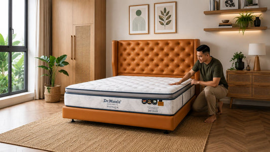 Male Malay Singaporean checking a knit cover mattress on a tan tufted bed frame in a modern Singapore bedroom