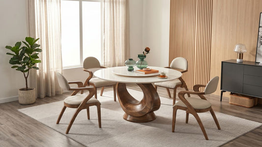 Round dining table collection with white tabletop, sculptural wood base, and cream dining chairs in a warm Singapore home dining area