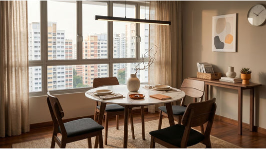 Round marble dining table with wooden chairs in a modern Singapore 2-bedroom condo dining area with HDB view and warm natural light