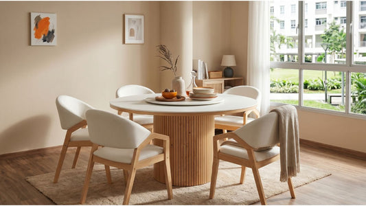 Round wood dining table with white chairs on a neutral rug in a bright Singapore HDB dining room