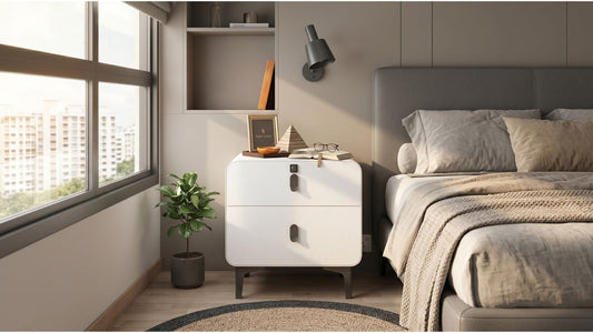 White chest of drawers beside a bed in a modern Singapore bedroom, styled with books, lamp, plant, and reading-friendly storage